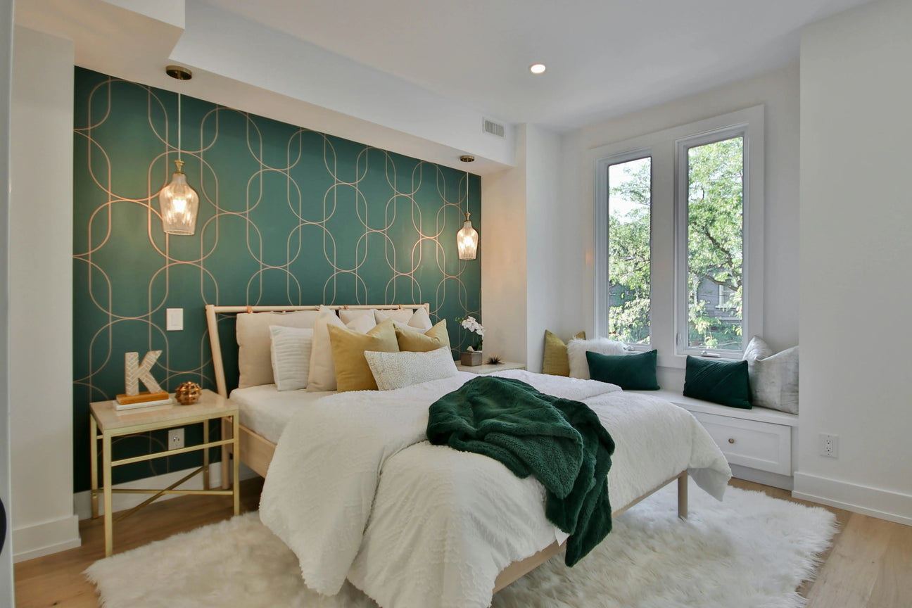 Stylish bedroom featuring soft cotton bedding, green throw blanket, and gold pendant lights for a cozy vibe.