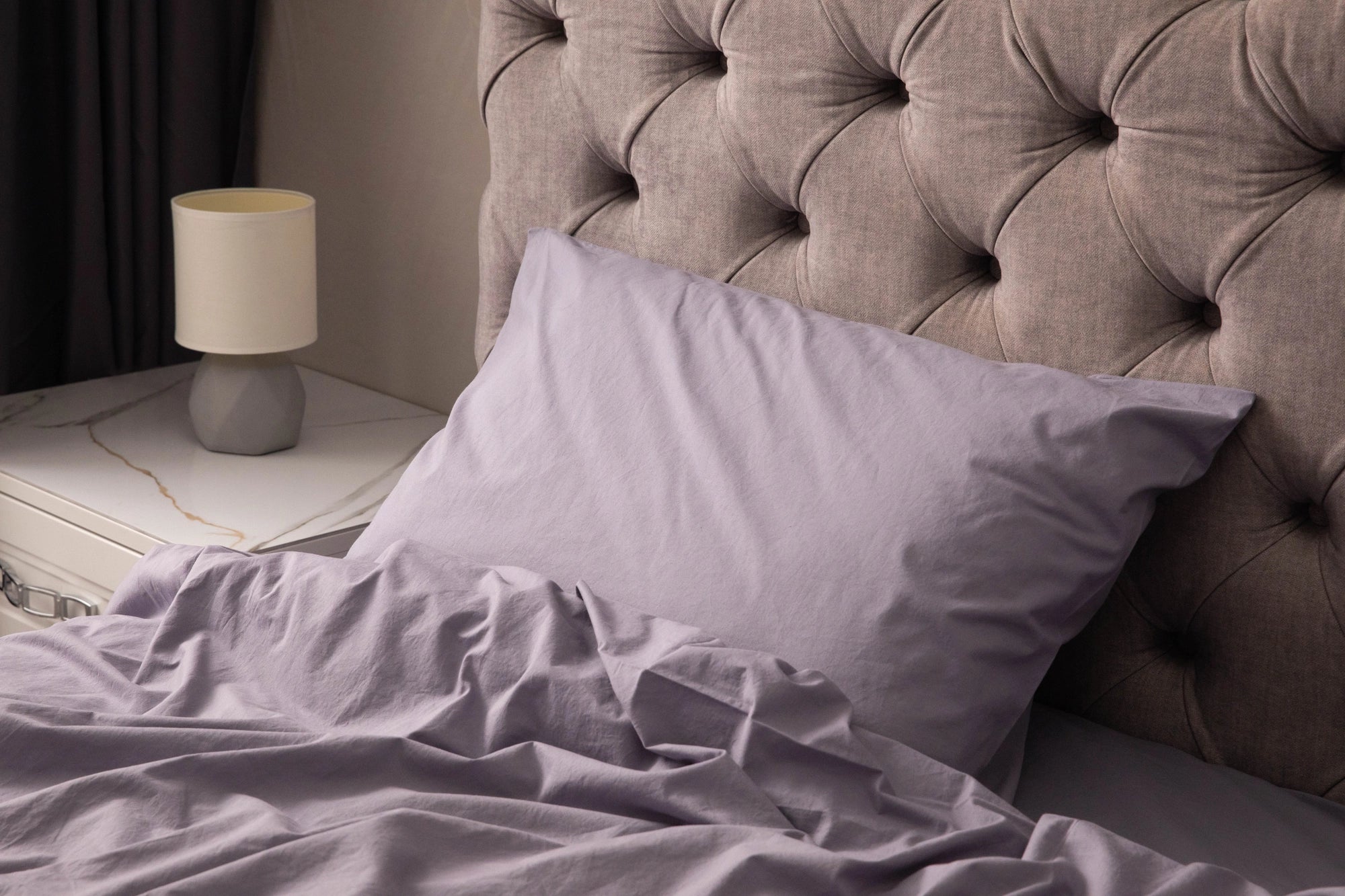 Supreme Rest’s lavender bedding set, styled against a tufted headboard, showcases our eco-conscious craftsmanship—where every wrinkle speaks to softness, comfort, and refined simplicity