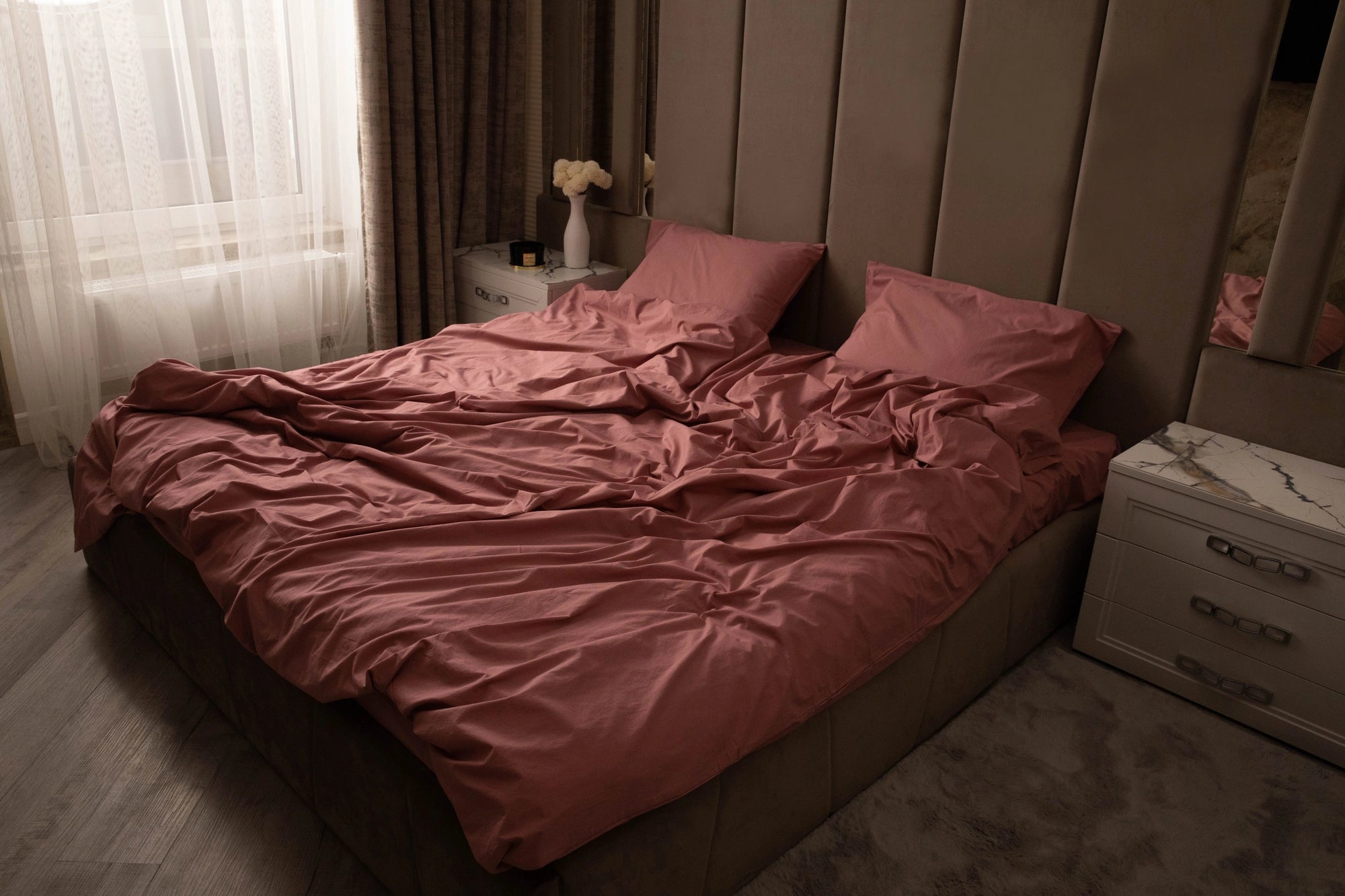 Supreme Rest rosewood-toned bedding draped over a king bed in soft morning light—eco-friendly cotton crafted for everyday luxury and serene, custom comfort