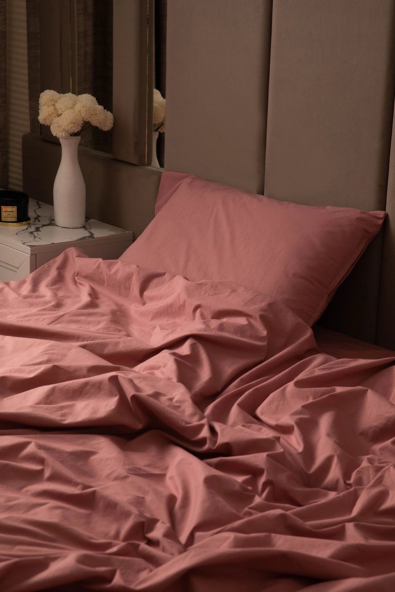 A close-up of Supreme Rest’s custom made rose bedding, styled with soft lighting and elegant decor—crafted for cozy, eco-friendly luxury