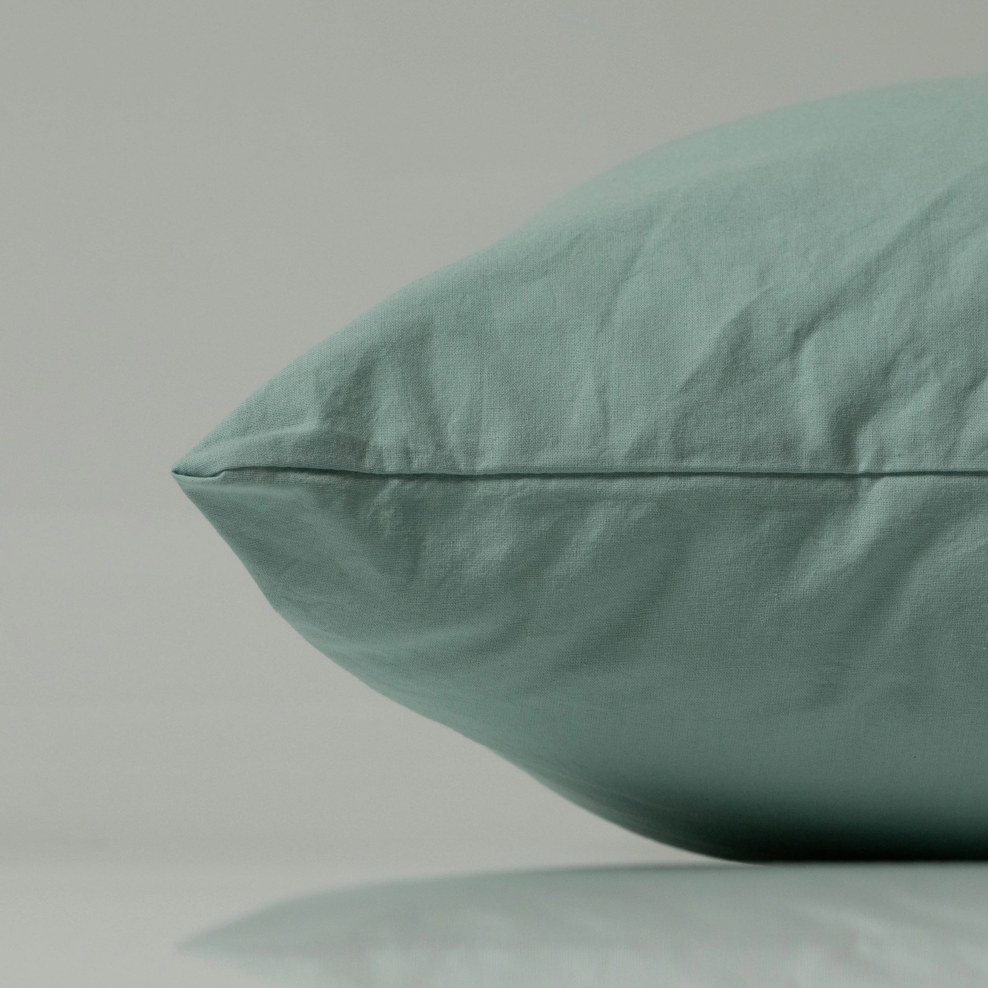 Close-up of a mint green pillow from Supreme Rest, showcasing custom made stitching and eco-friendly fabric in a soft, contemporary finish