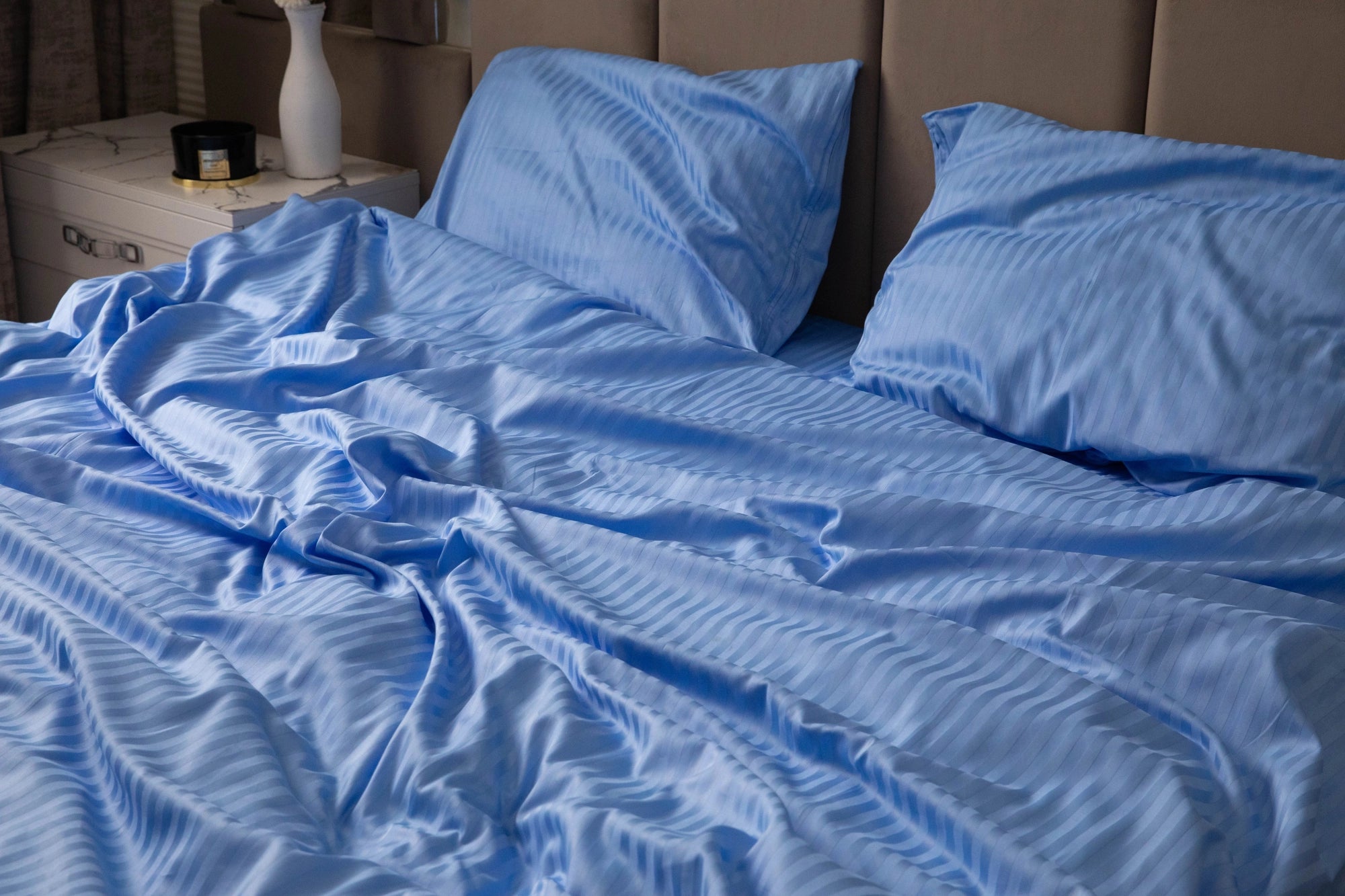 Smooth and silky Celestial Blue duvet cover draped over a bed, showcasing its soft fabric.
