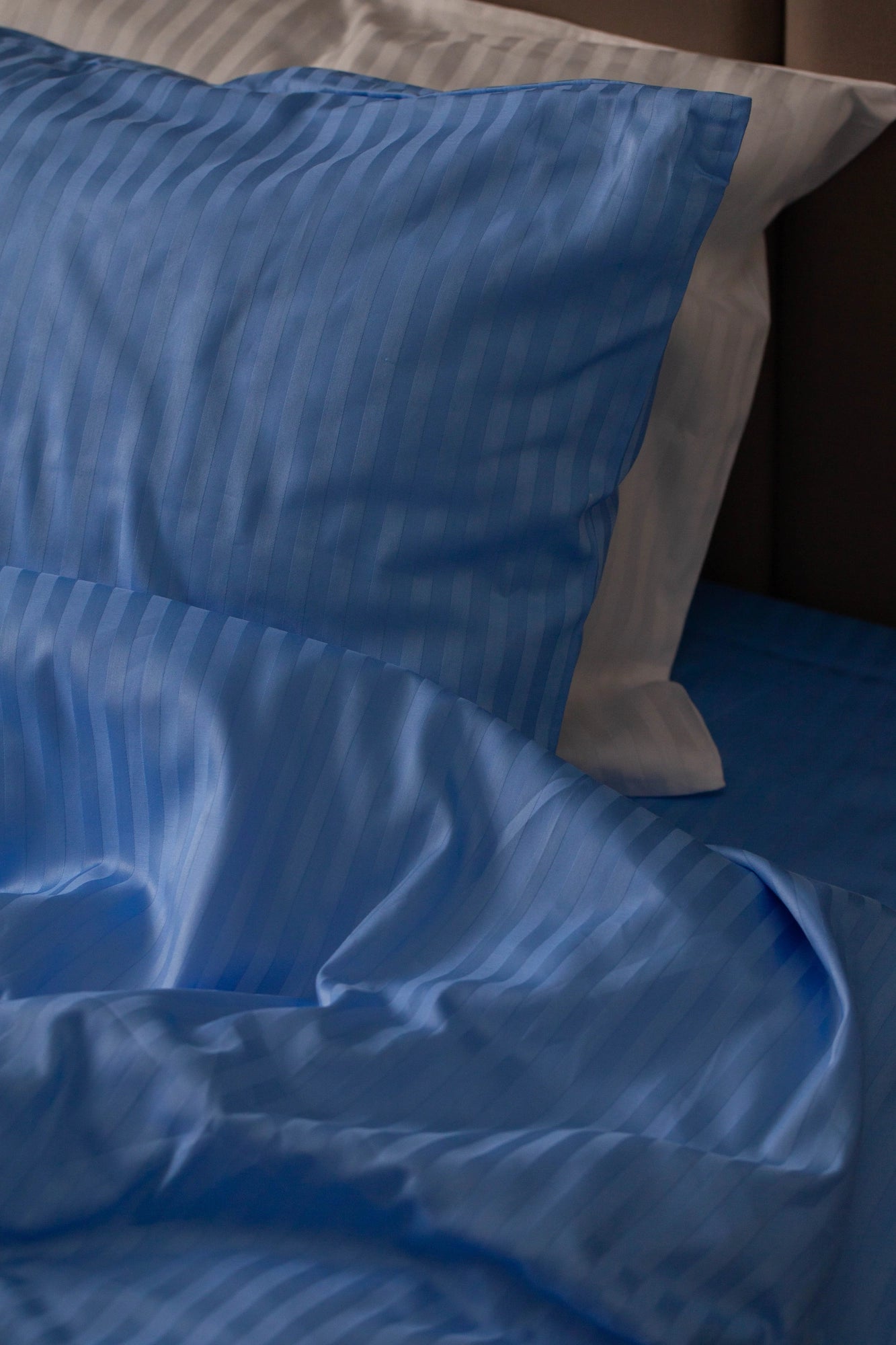 Deep blue sateen pillowcase and duvet cover set, adding elegance to any modern bedroom.