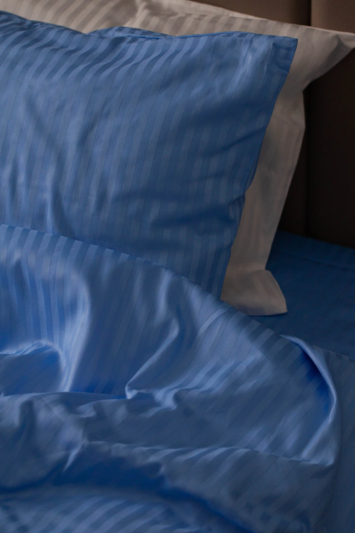Deep blue sateen pillowcase and duvet cover set, adding elegance to any modern bedroom.