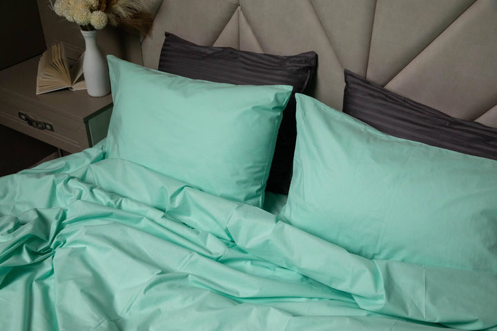 A modern bedroom featuring a bed dressed in Supreme Rest Glacial Waters ranforce bedding