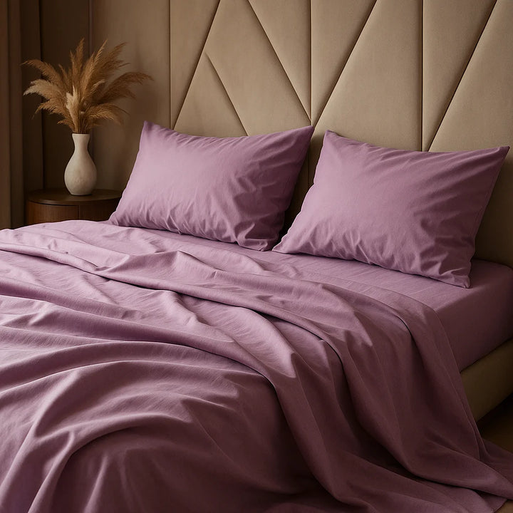 Soft plum sheets by Supreme Rest—elegant folds, a neutral backdrop, and a calming touch of pampas for that minimalist-chic feel