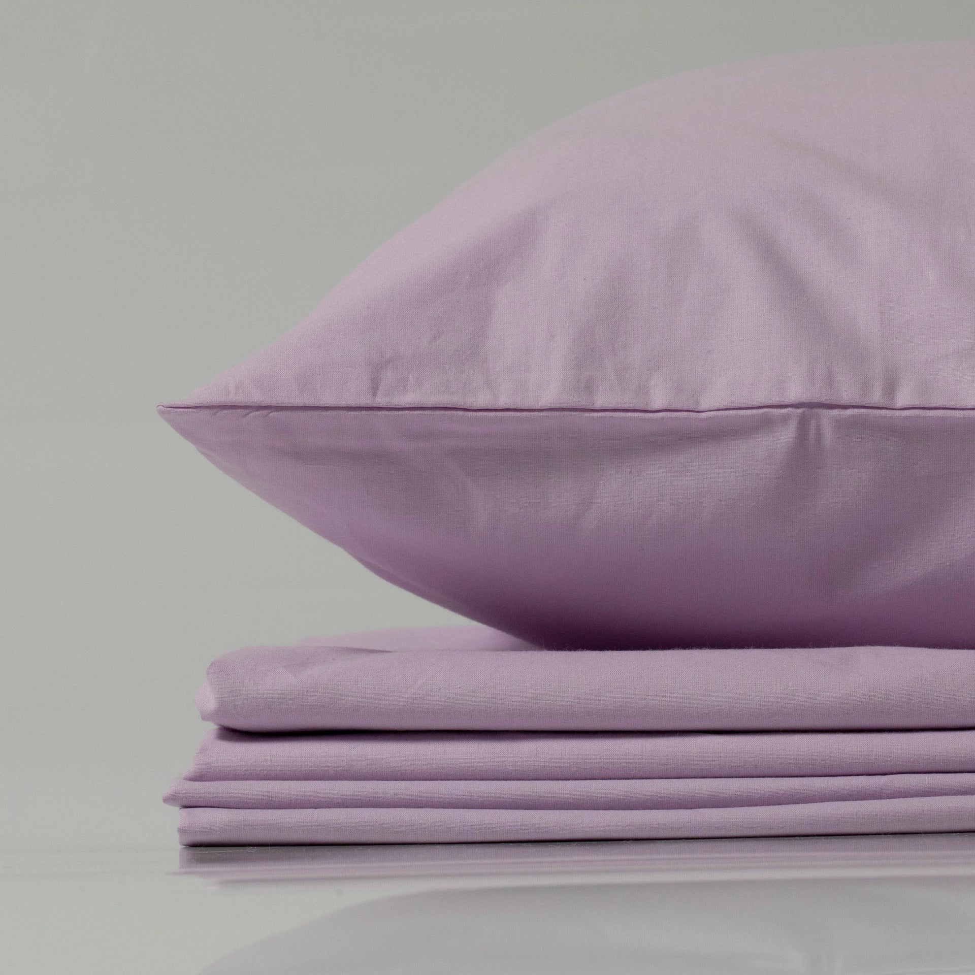 Close-up of a lilac-colored pillow on a matching folded Supreme Rest ranforce bedding set