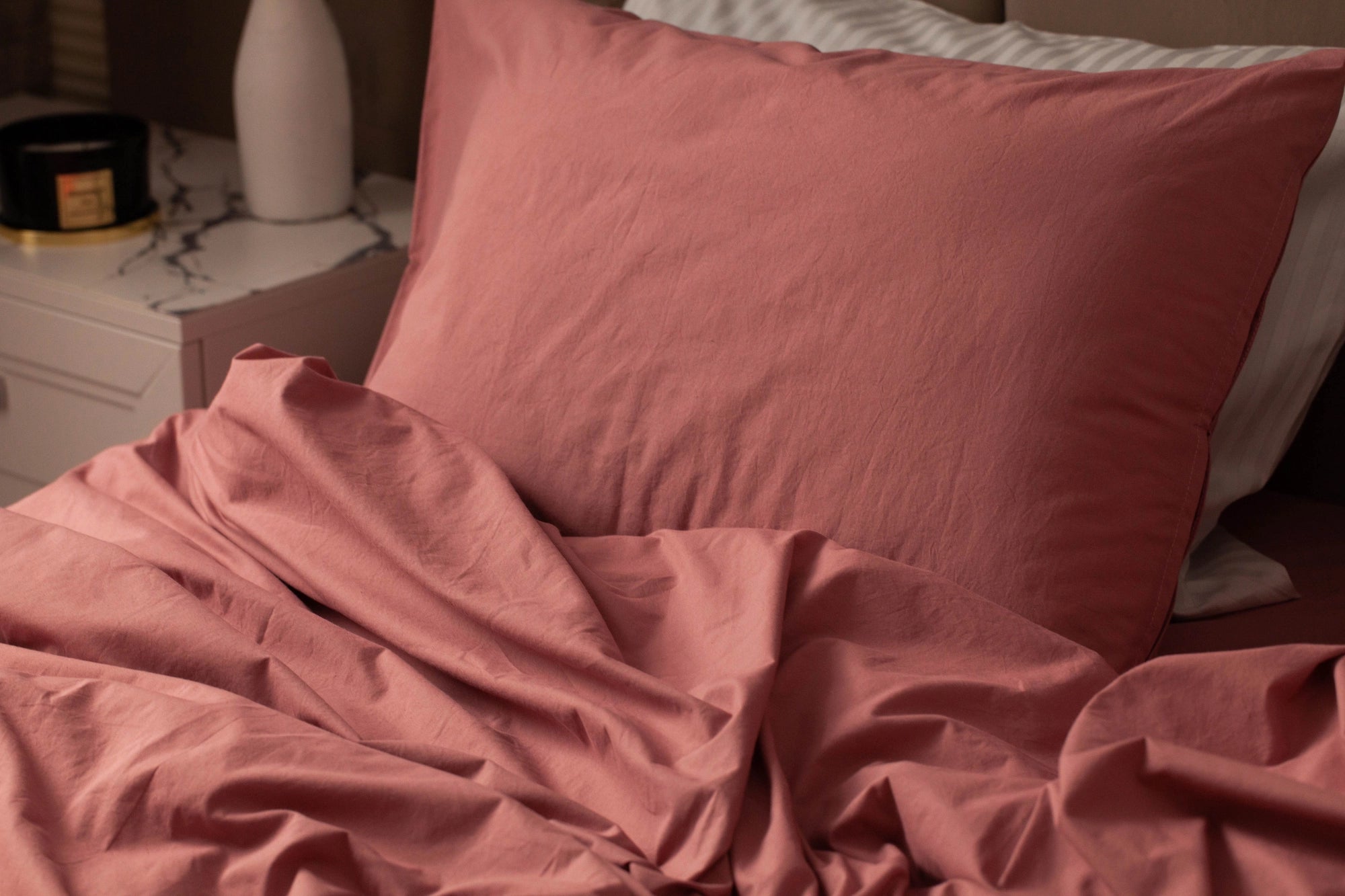 Close-up of Supreme Rest’s rosewood cotton pillow and bedding—crafted for softness and elegance with eco-friendly materials and a refined custom-made touch