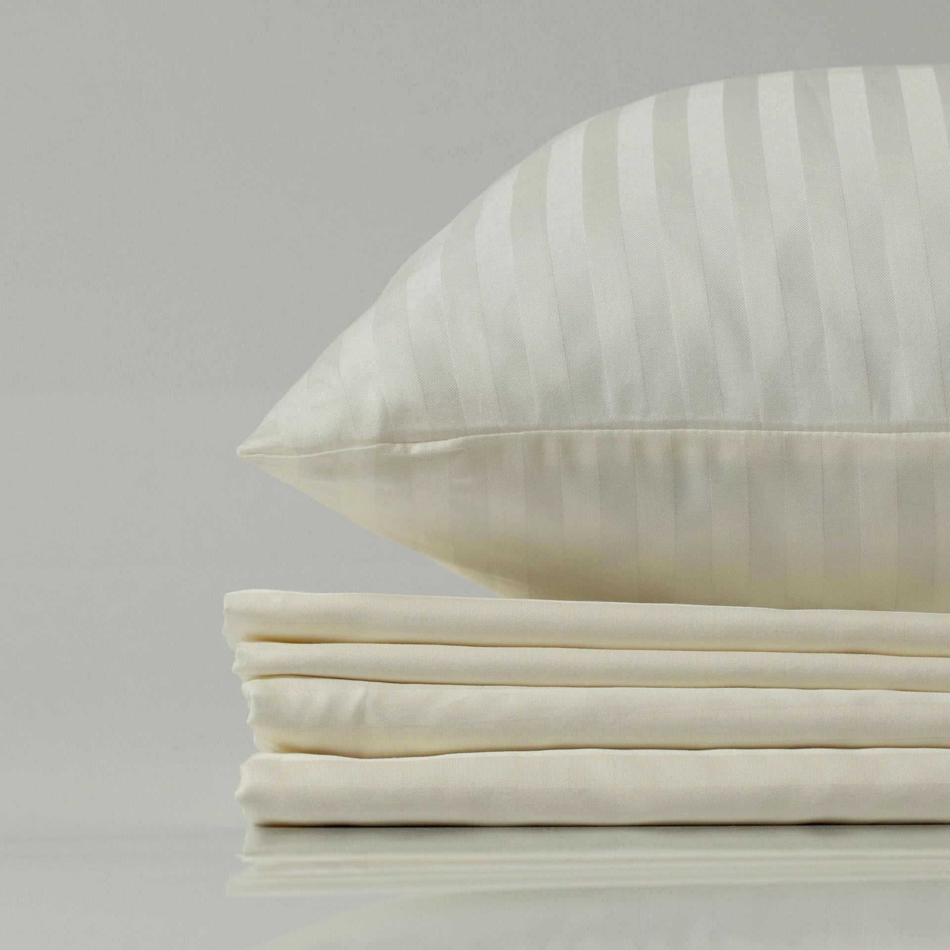 Close-up of silky-smooth Supreme Rest Ivory Dune sateen fabric, highlighting its delicate sheen.