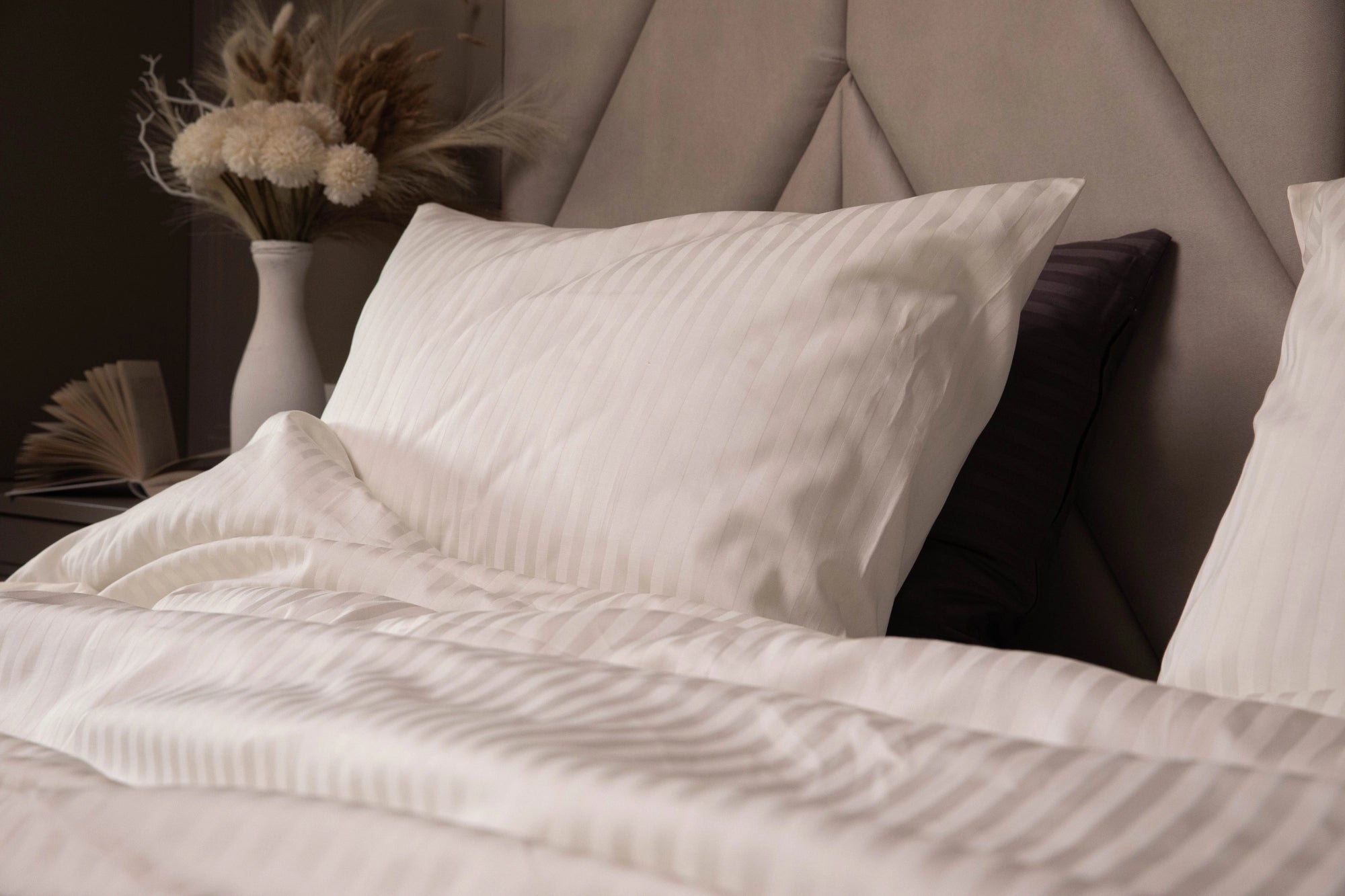 Luxurious Ivory Dune bedding set with silky pillowcases and a duvet cover on a modern bed.
