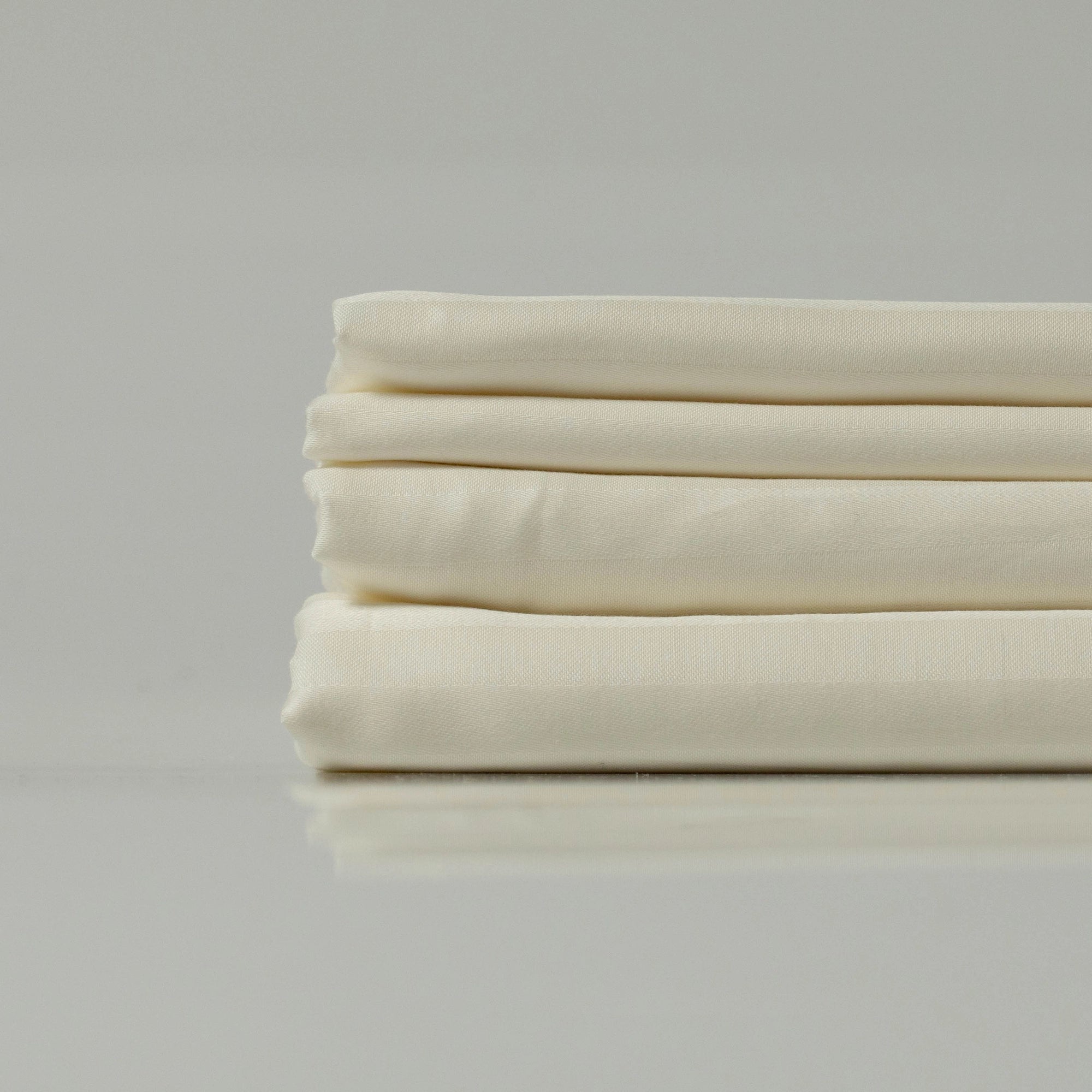 Smooth and crisp Ivory Dune flat sheet folded neatly, highlighting its high-thread-count sateen.