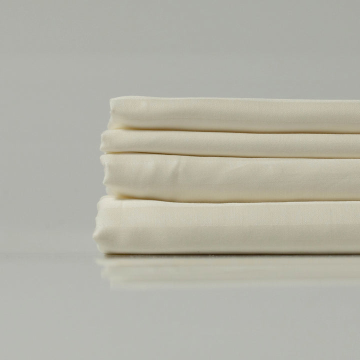 Smooth and crisp Ivory Dune flat sheet folded neatly, highlighting its high-thread-count sateen.
