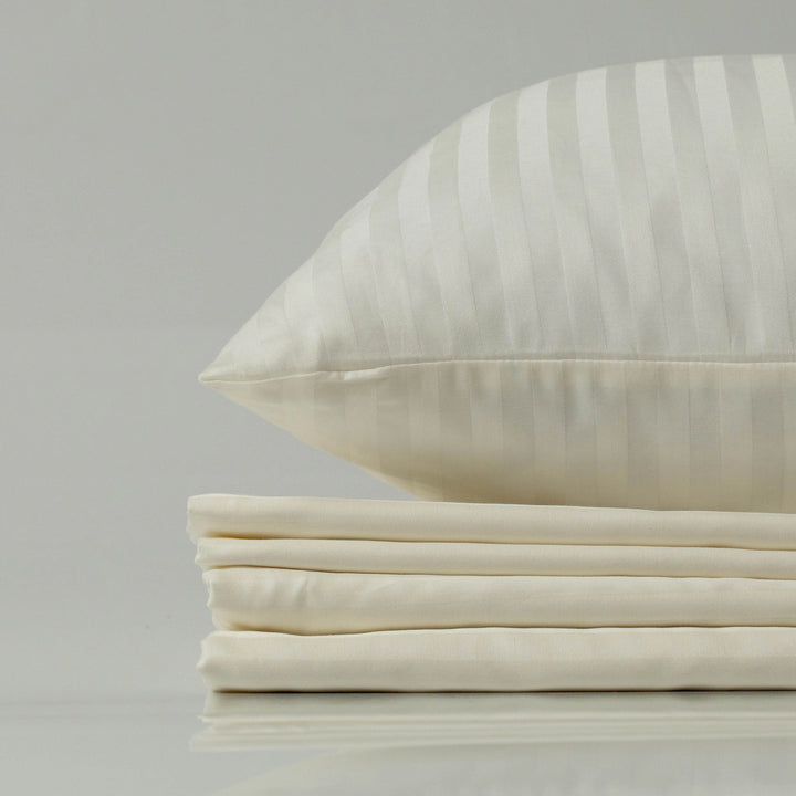 Supreme Rest Ivory Dune striped sateen pillowcase on a neatly stacked bedding set.