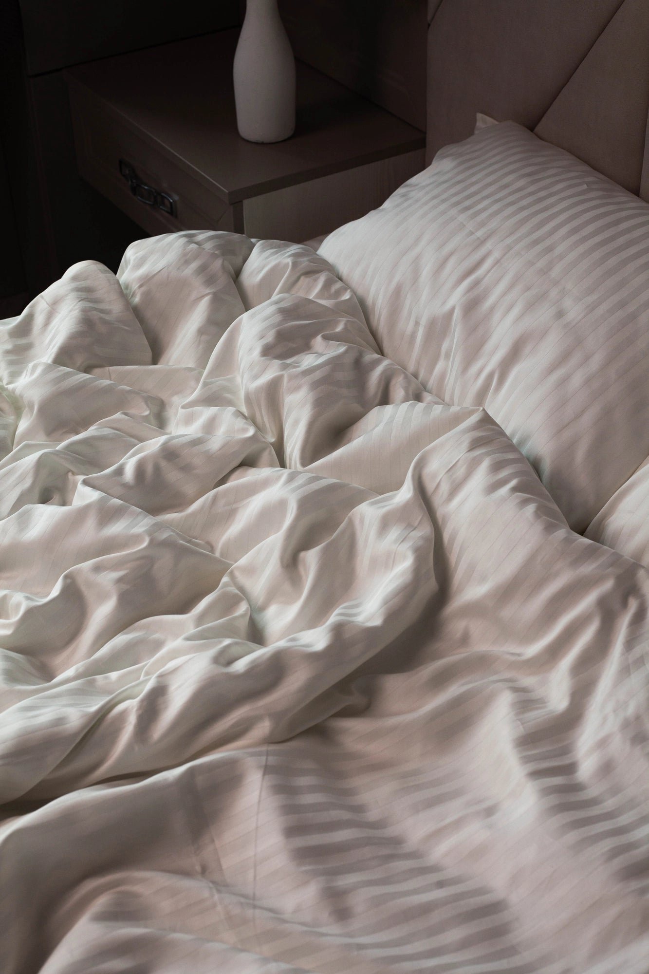 Relaxing bedroom setting with Supreme Rest Ivory Dune bedding, styled with soft lighting and decor.