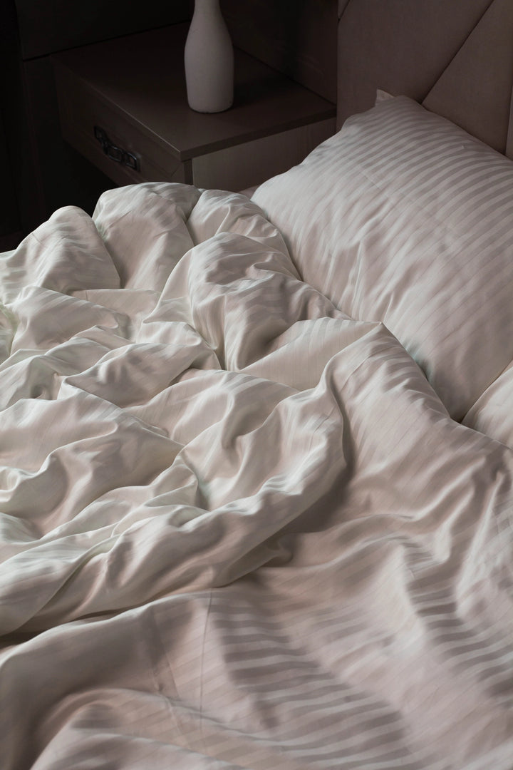 Relaxing bedroom setting with Supreme Rest Ivory Dune bedding, styled with soft lighting and decor.