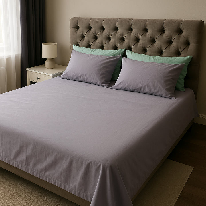 Modern tufted bed dressed in soft lavender cotton sheets with mint green accent pillows—Supreme Rest’s calming duo for a fresh, stylish sleep space