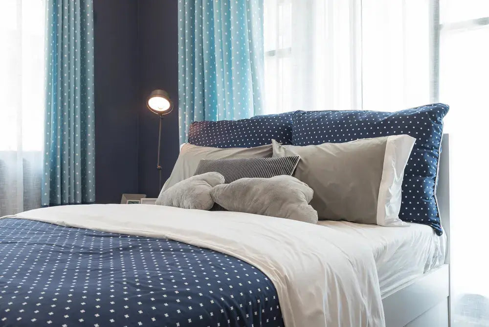 Supreme Rest eco-friendly custom-made bedding in a modern bedroom with blue star-patterned design and cozy neutral pillows.