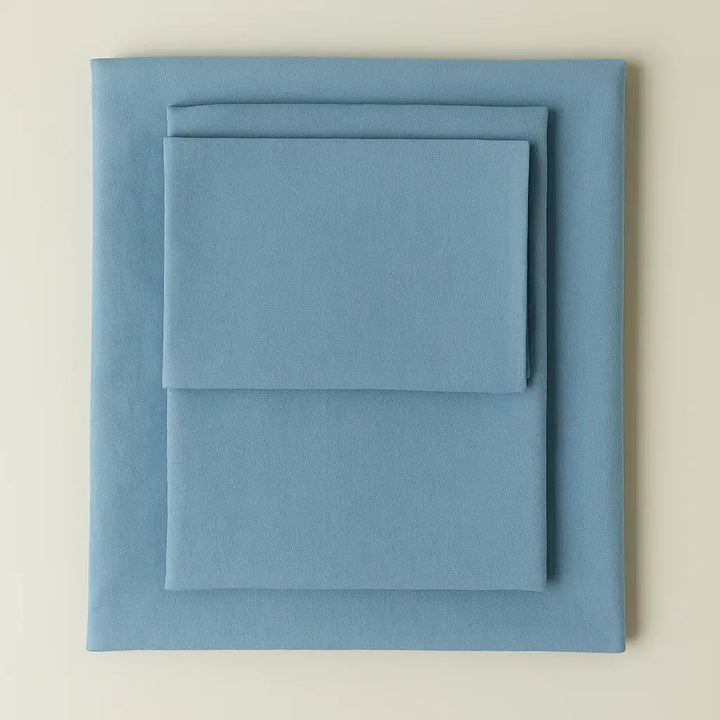 Supreme Rest eco-friendly custom-made bedding set in soft blue – folded sheets and pillowcase for luxurious, sustainable sleep.