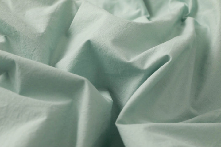 Close-up of Supreme Rest’s eco-friendly fabric in sage green, capturing the gentle drape and fine craft of custom made bedding