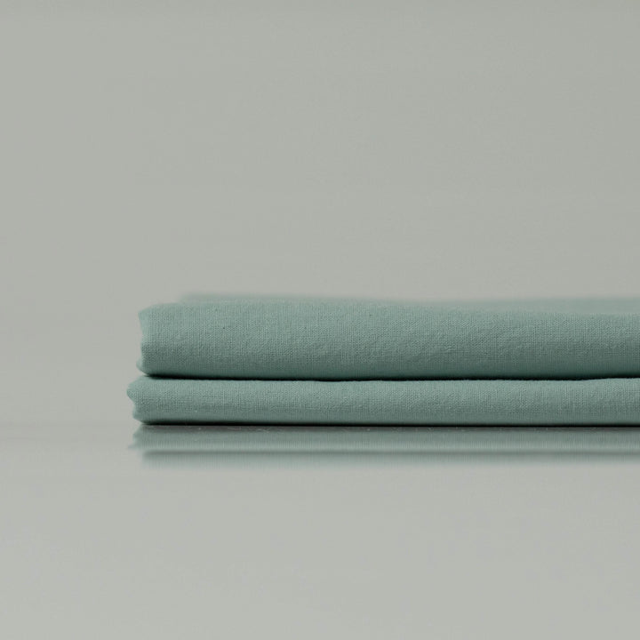 Folded eco-friendly fabric in mint green - custom made and crafted by Supreme Rest for sustainable bedding essentials.