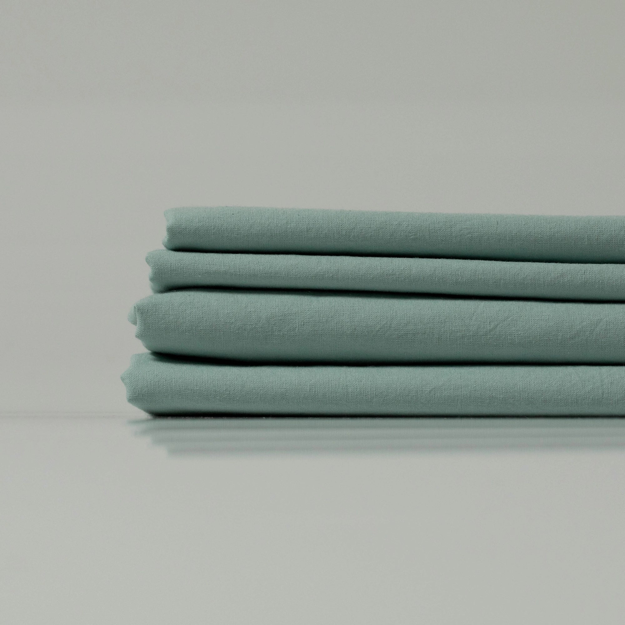 Mint green folded eco-friendly fabric - custom-crafted by Supreme Rest for sustainable bedding essentials.