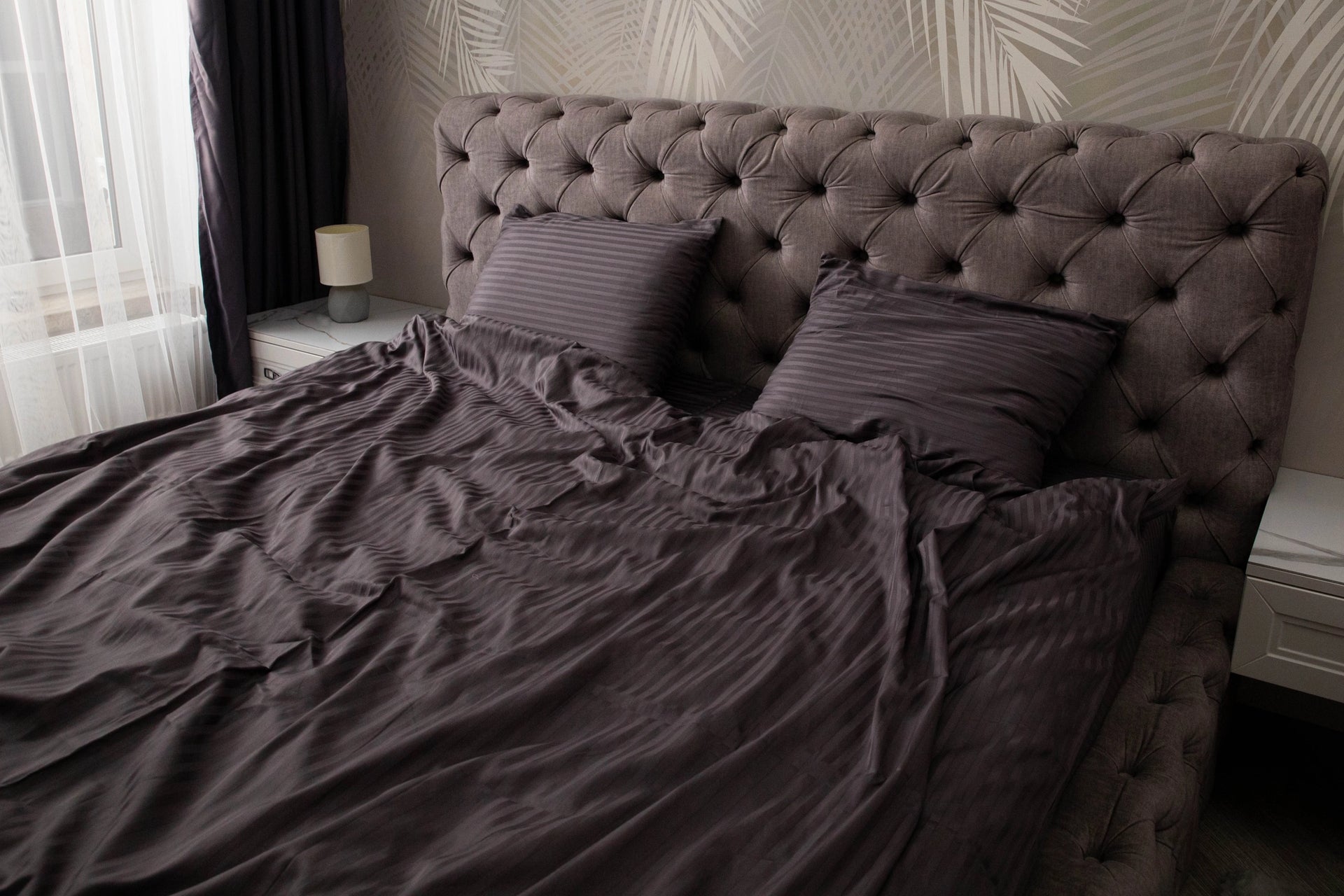 Supreme Rest eco-friendly bedding set in deep plum with subtle stripes, elegantly styled on a tufted headboard bed for a custom-made luxury bedroom feel