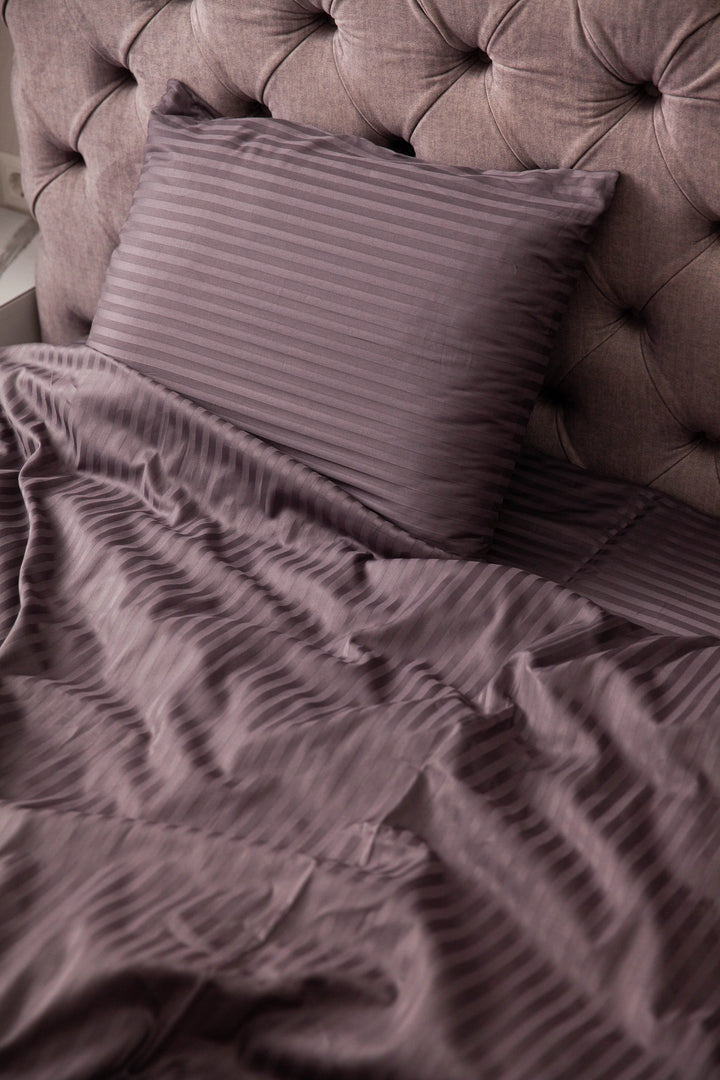 Supreme Rest custom made striped bedding in a deep plum tone, styled on a tufted headboard bed for a luxurious and eco-friendly bedroom aesthetic