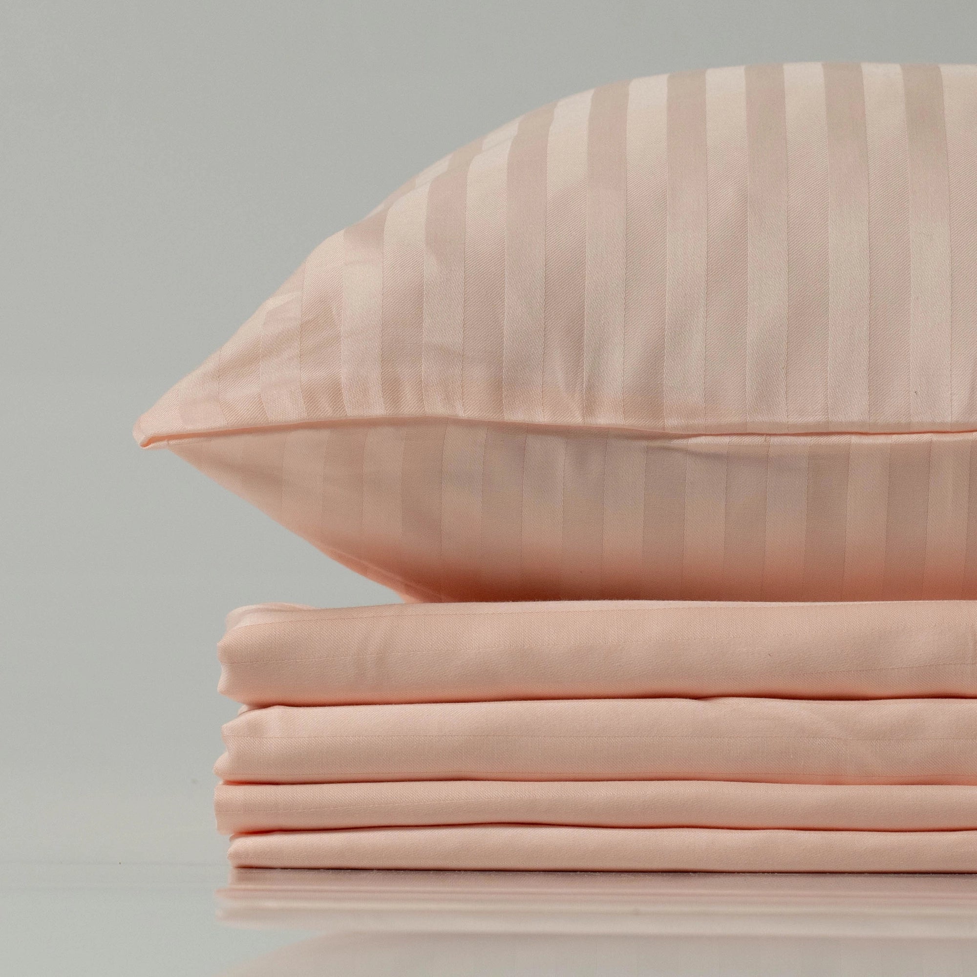 Elegant blush peach bedding set from Supreme Rest, custom made with a silky sateen stripe finish and eco-friendly craftsmanship