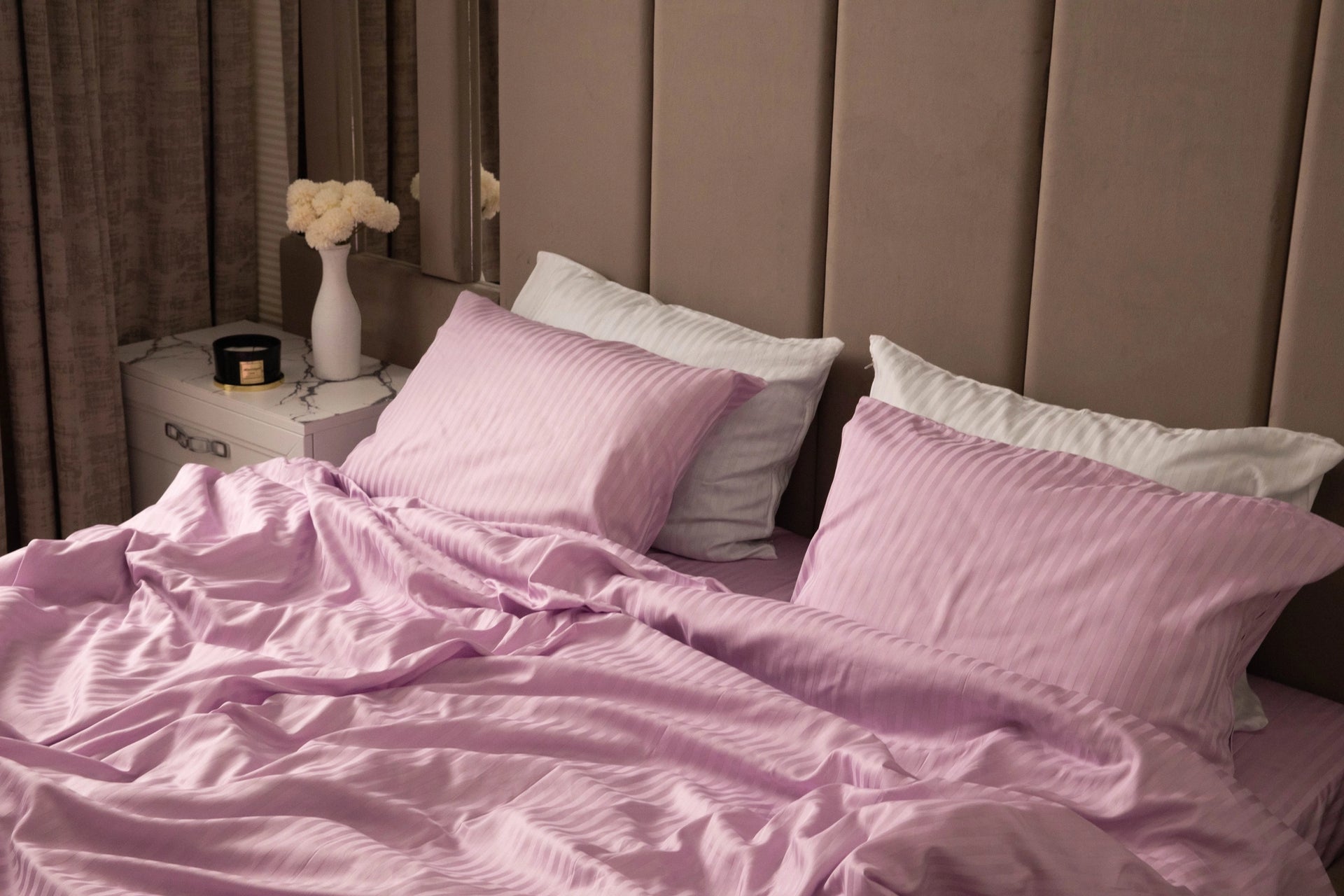 Supreme Rest bed dressed in lilac-striped sheets and pillowcases, blending custom-made luxury with an eco-friendly, crafted design for serene sleep spaces