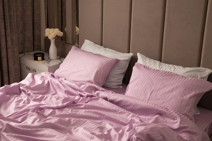 Supreme Rest bed dressed in lilac-striped sheets and pillowcases, blending custom-made luxury with an eco-friendly, crafted design for serene sleep spaces