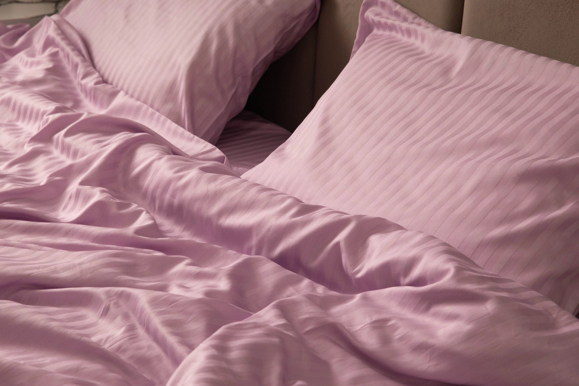 Close-up of Supreme Rest’s custom lilac-striped bedding, showcasing the crafted, eco-friendly fabric and silky texture designed for elevated comfort