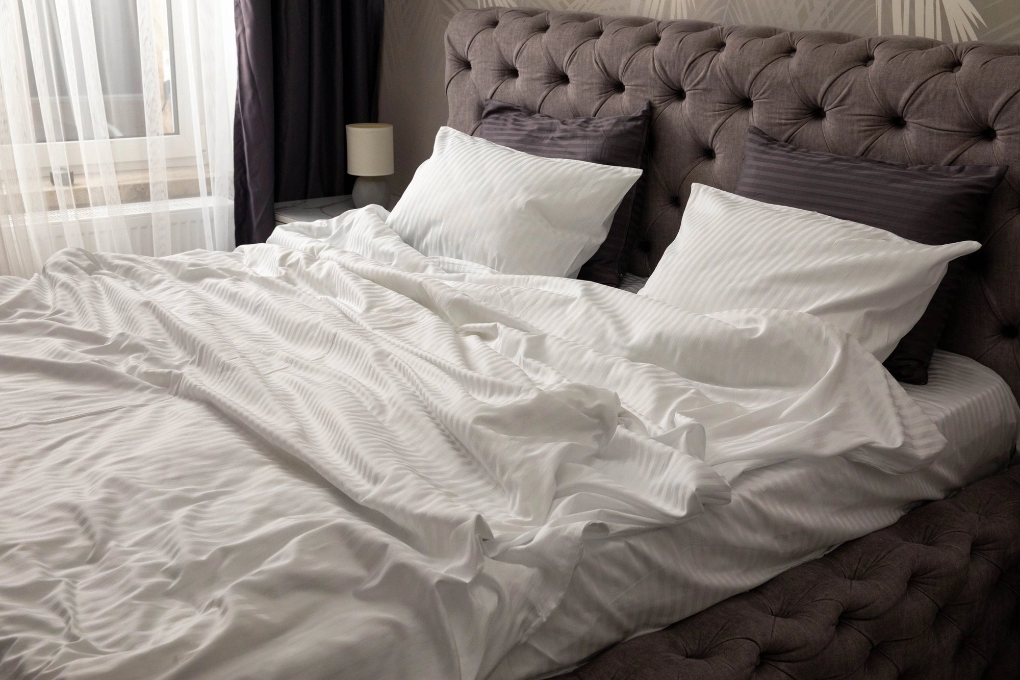 Supreme Rest custom made white striped bedding in a cozy, softly lit bedroom, crafted for eco-friendly luxury and unmatched sleep comfort