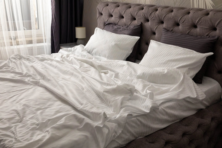 Supreme Rest custom made white striped bedding in a cozy, softly lit bedroom, crafted for eco-friendly luxury and unmatched sleep comfort