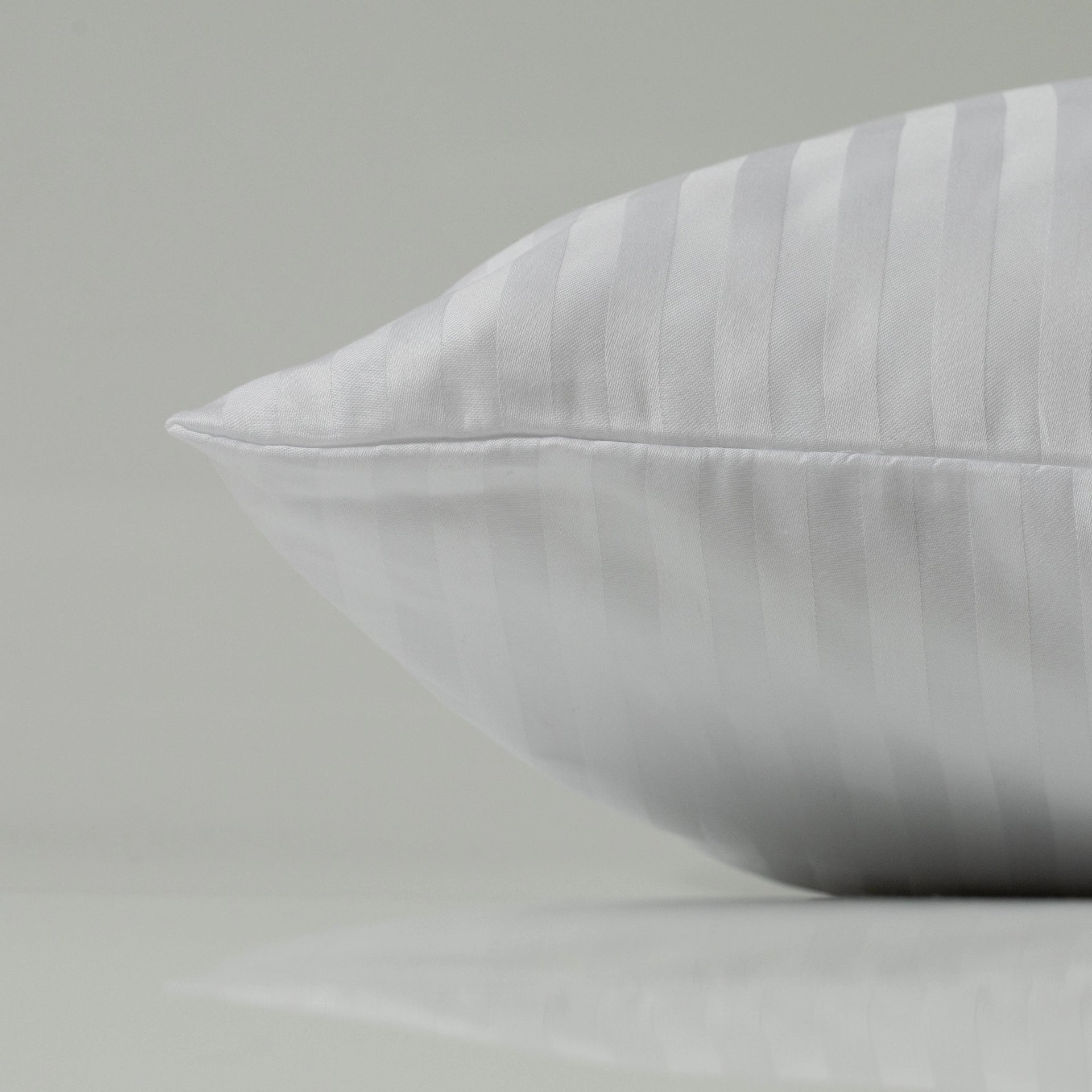 A snow-white pillowcase with elegant sateen stripes, showcasing its smooth texture and tailored seam for a refined, polished finish