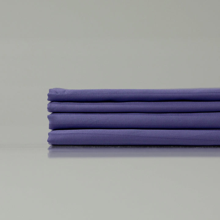 Neatly arranged deep purple sateen bedding set, emphasizing breathable and silky smooth fabric.