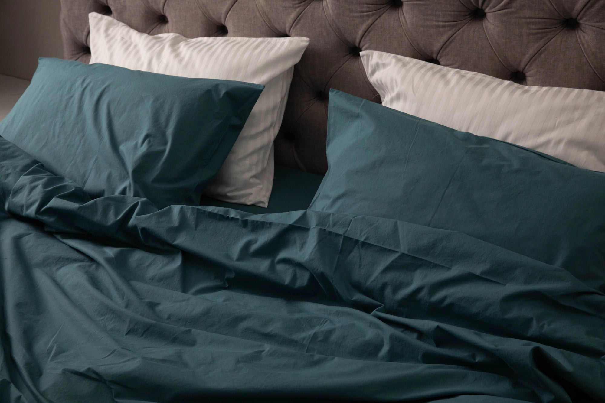 Luxurious Supreme Rest bed dressed in deep teal Stonewashed Cotton bedding, paired with white striped pillows and a tufted headboard for a refined, cozy bedroom look