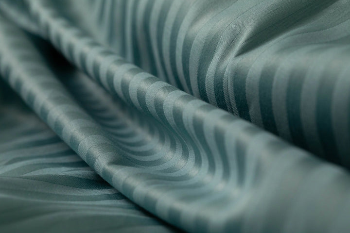 Teal striped fabric from Supreme Rest, showcasing its silky texture and custom-woven, eco-friendly craftsmanship