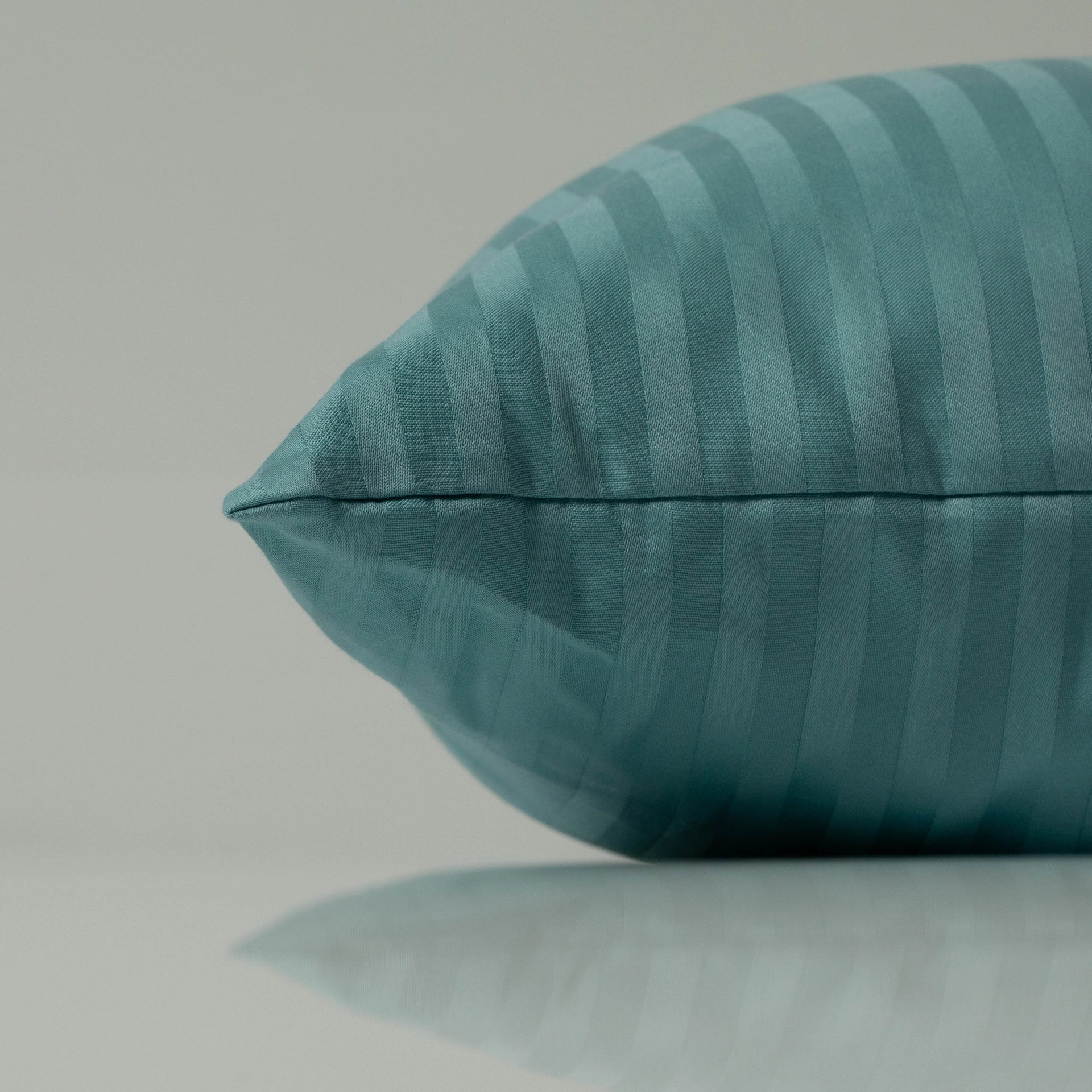 Ocean blue pillow with a subtle stripe design, highlighting a handcrafted touch and the refined texture of high-quality woven fabric