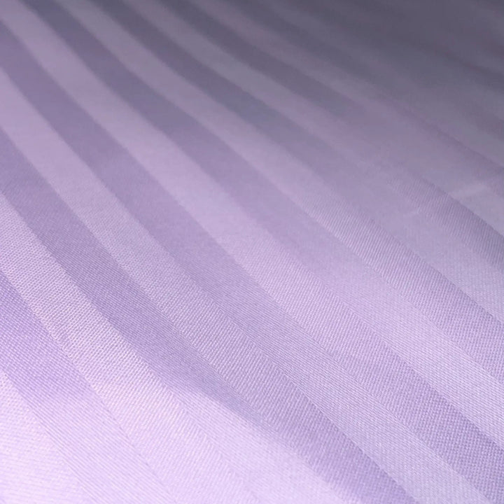 Close-up of Supreme Rest striped lavender sateen sheet – handcrafted, eco-friendly bedding for luxury sleep.